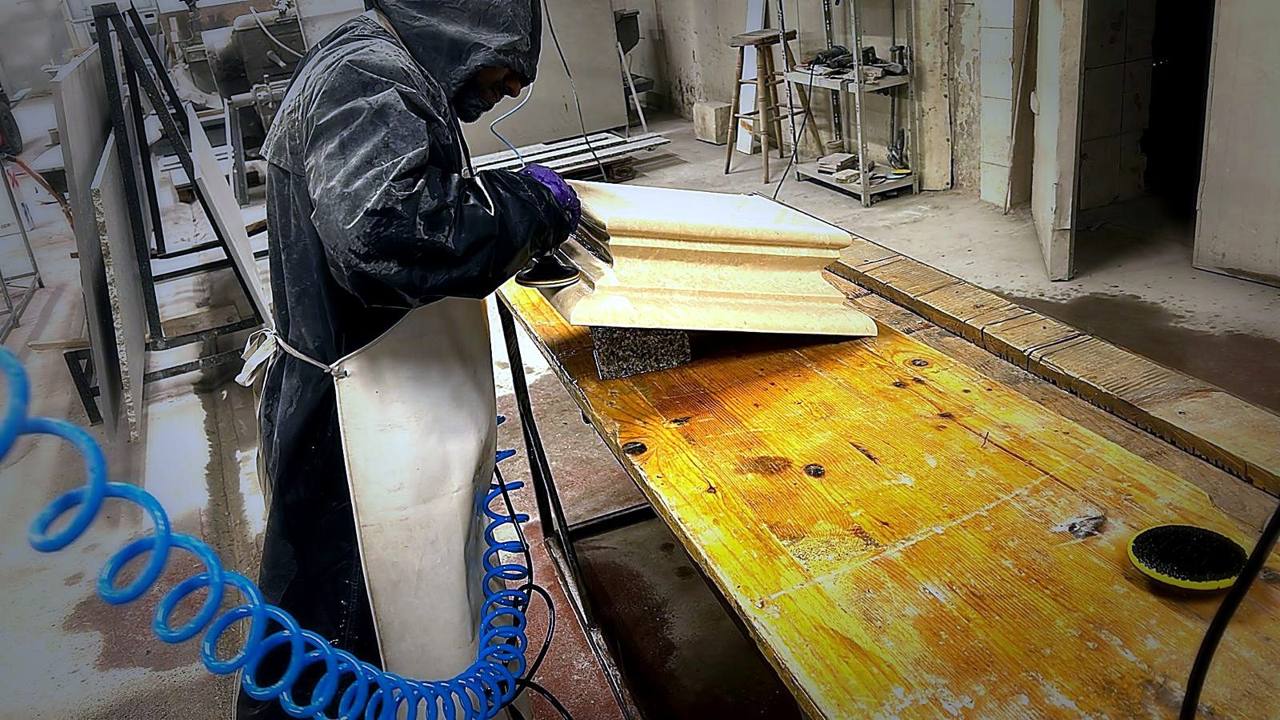 Meșter șlefuind manual un profil din piatră în atelier